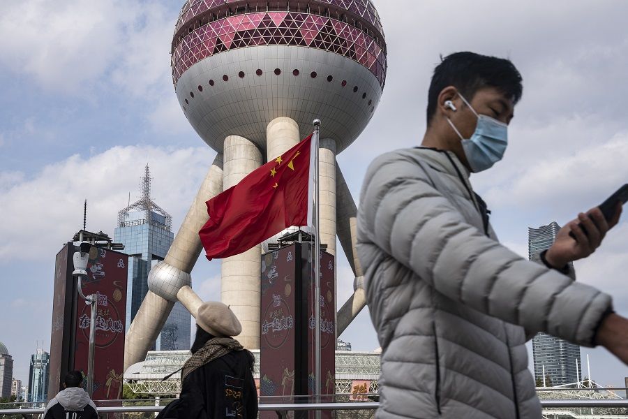 Pedestrians walk past a Chinese flag in the Lujiazui financial district in Shanghai, China, on 1 December 2020. (Qilai Shen/Bloomberg)