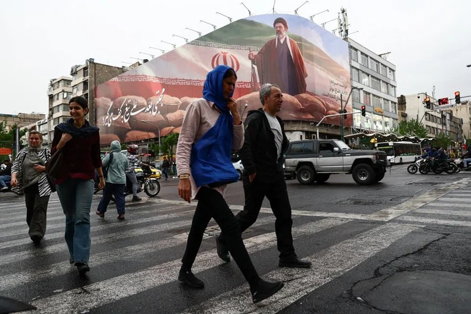 People walk near a billboard featuring an image of Iran’s new Supreme Leader Mojtaba Khamenei, amid a ceasefire between US and Iran, in Tehran, Iran, on 20 April 2026. (Majid Asgaripour/West Asia News Agency via Reuters)