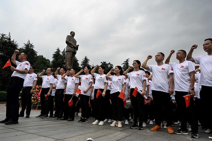 This photo taken on 26 May 2021 shows party members taking an oath next to a bronze statue of late Chinese communist leader Mao Zedong in Shaoshan, Hunan province, China. (Jade Gao/AFP)