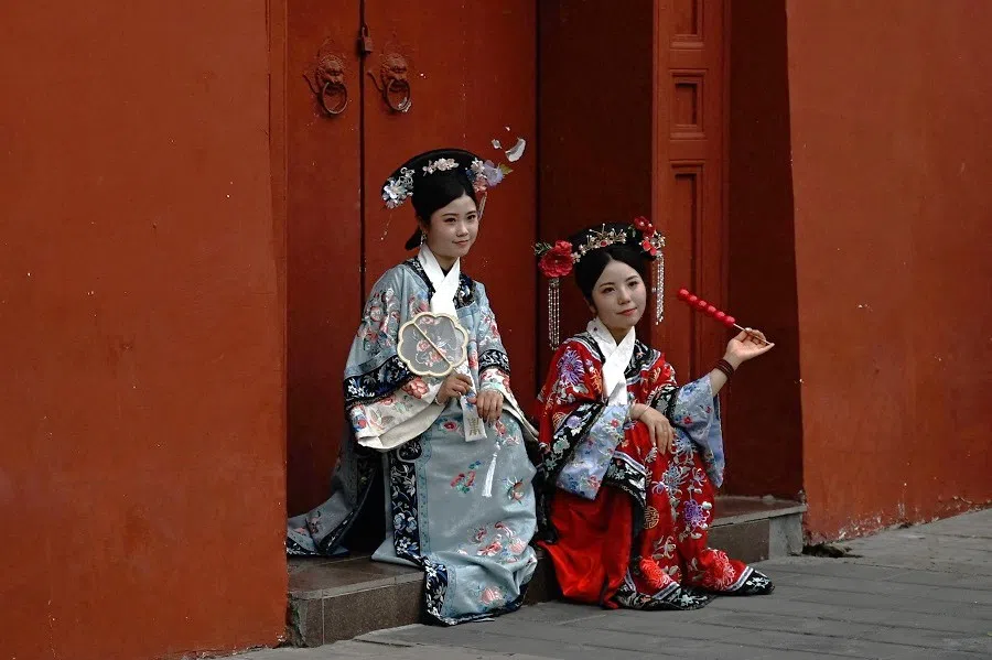 Women wearing traditional costumes pose at the Forbidden City in Beijing, China, on 7 July 2024. (Pedro Pardo/AFP)