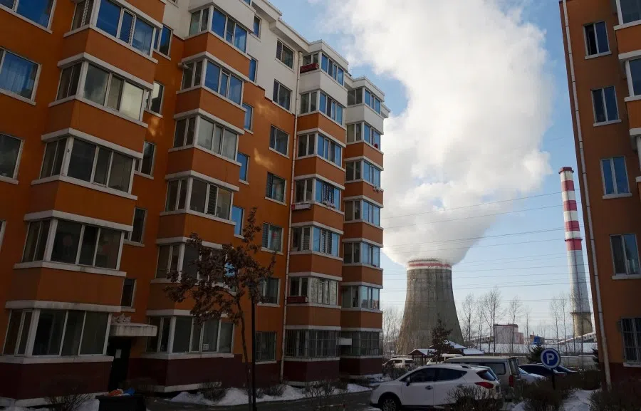 Smoke billows from a cooling tower of a thermal power plant near residential buildings in the coal city of Hegang, Heilongjiang province, northeast China, 2 January 2020. (Ryan Woo/Reuters)