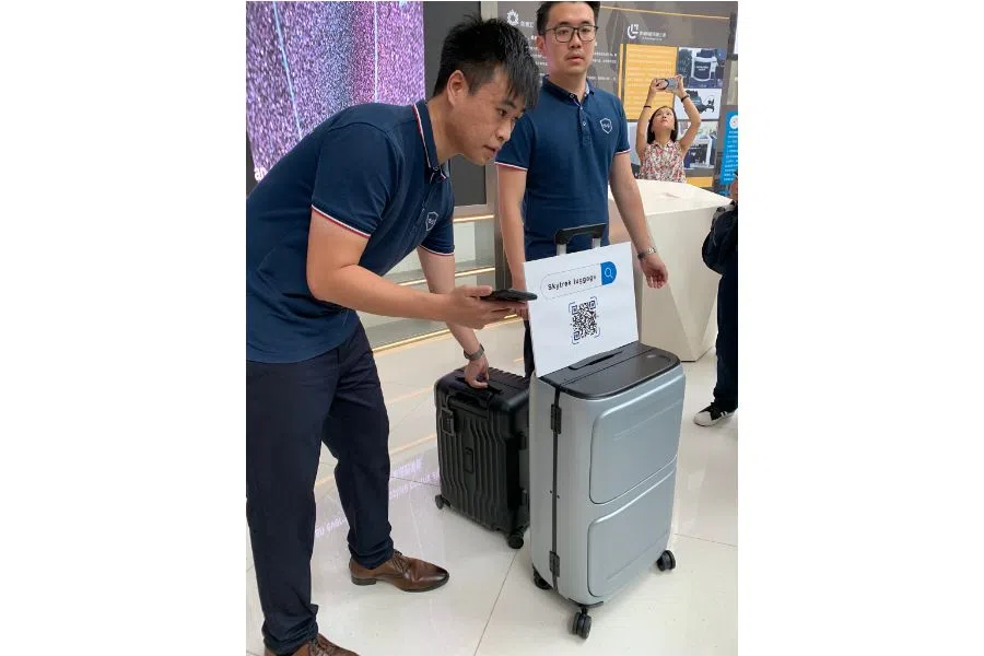 At the Qianhai "Dream Factory", young Hong Kong entrepreneur Kwok Wai-keung (left) demonstrates the smart luggage that he and his team have developed, equipped with location and self-weighing capabilities. (Photo: Han Yong Hong)