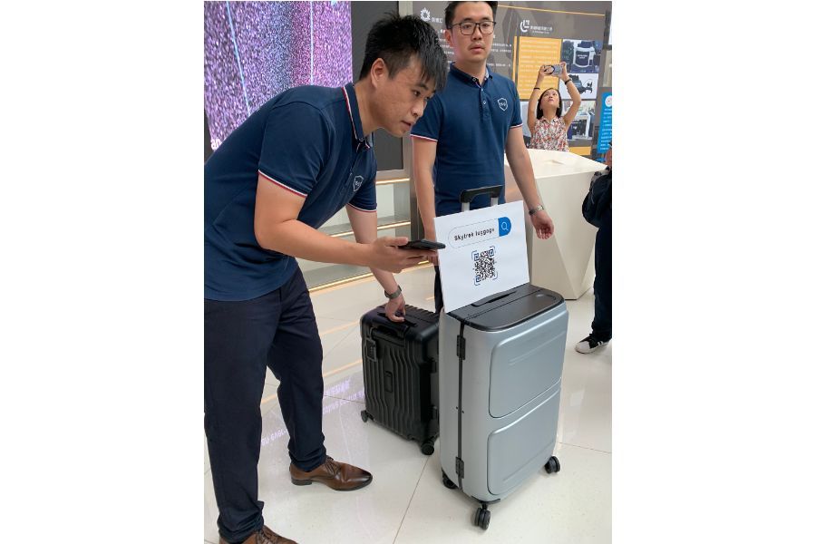 At the Qianhai "Dream Factory", young Hong Kong entrepreneur Kwok Wai-keung (left) demonstrates the smart luggage that he and his team have developed, equipped with location and self-weighing capabilities. (Photo: Han Yong Hong)
