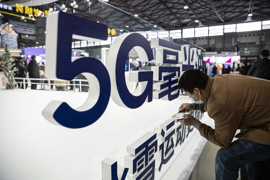 A worker makes finishing touches to a signage for 5G mmWave at the MWC Shanghai exhibition in Shanghai, China, on 23 February 2021. (Qilai Shen/Bloomberg)