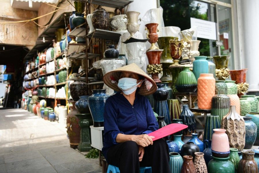 A woman waits for customers at a pottery shop in Hanoi on 29 June 2021. (Nhac Nguyen/AFP)
