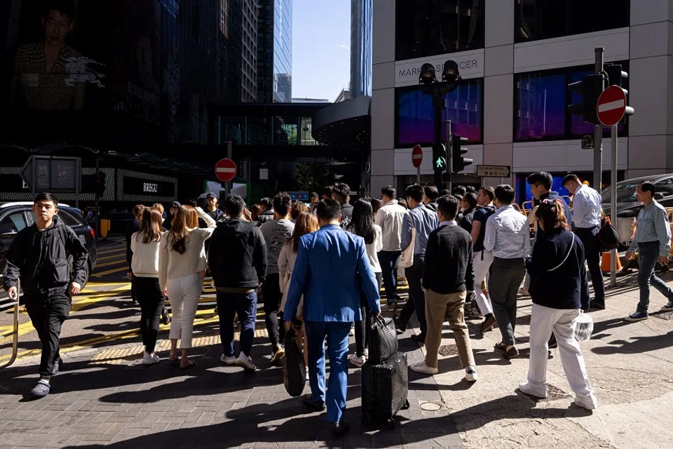 Office workers walk on a street during lunch hour in the Central district in Hong Kong, China, on 20 November 2023. (Paul Yeung/Bloomberg)