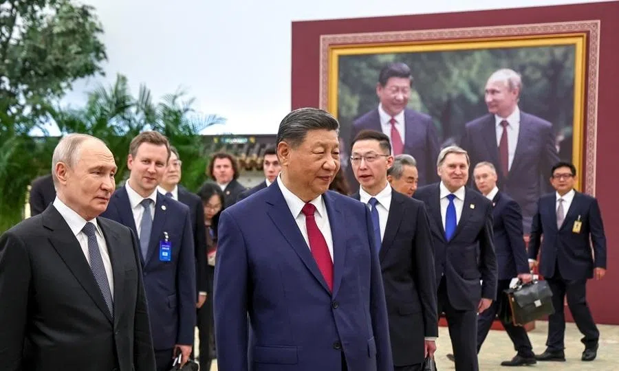 Russian President Vladimir Putin and Chinese President Xi Jinping tour a photo exhibition by the TASS and Xinhua news agencies at the Great Hall of the People in Beijing, China, 20 May 2026.