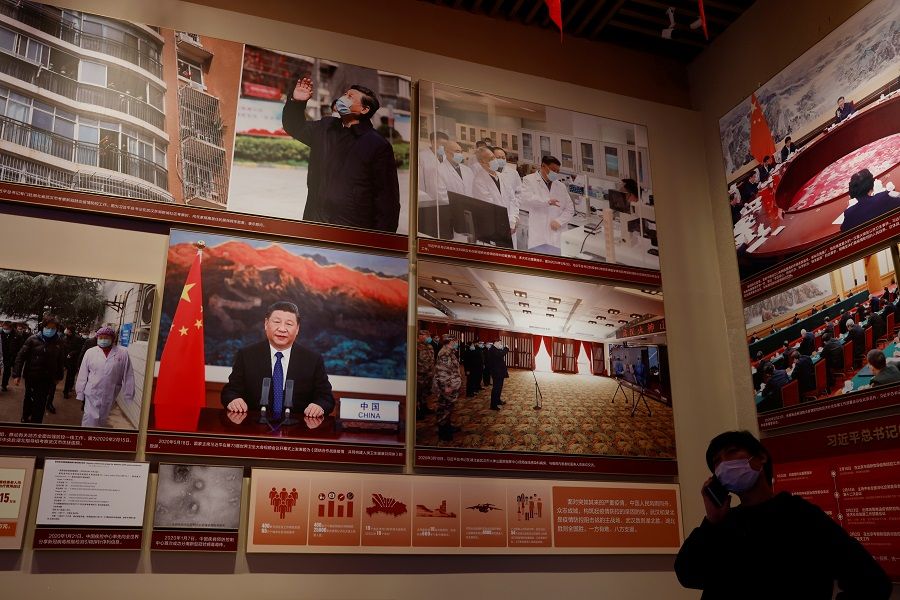A man stands near images of Chinese President Xi Jinping at a section on China's fight against the Covid-19 pandemic, at the Museum of the Communist Party of China in Beijing, China, 11 November 2021. (Carlos Garcia Rawlins/Reuters)