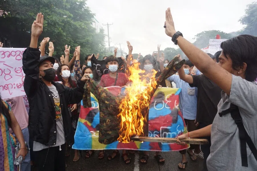 In this file photo taken on 1 July 2021 protesters burn a military uniform as they take part in a flash mob demonstration against the military coup in Yangon. (STR/AFP)