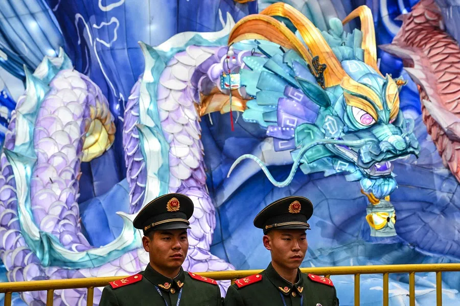 Chinese paramilitary policemen stand guard next to an illuminated installation of a dragon at the Yu Garden in Shanghai, China, on 13 February 2024.