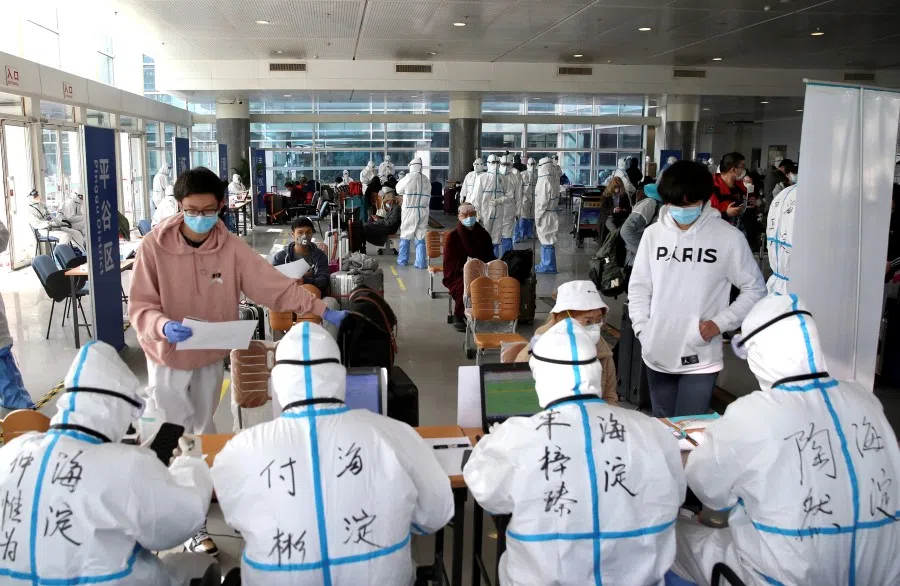 Passengers register their information at the New China International Exhibition Center, a transit hub to screen incoming passengers from the Beijing Capital International Airport for Covid-19, Beijing, March 18, 2020. (China Daily via REUTERS)