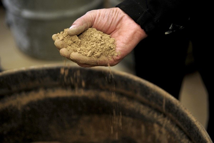 A Molycorp worker holds a handful of rocks containing rare earth elements during a media tour in Mountain Pass, California, U.S., 13 December 2010. (Jacob Kepler/Bloomberg)