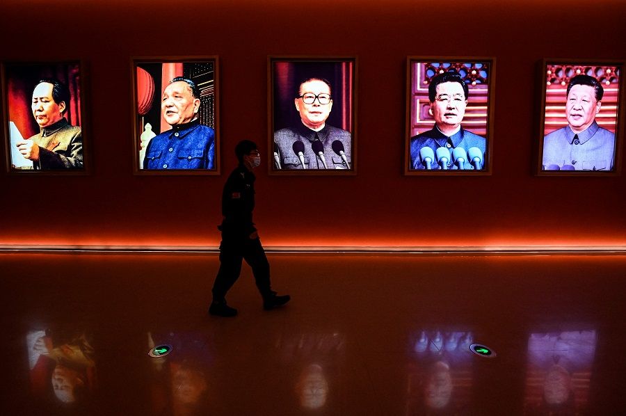 This file photo taken on 15 October 2022 shows a man walking past portraits of (left to right) late Chinese chairman Mao Zedong and former Chinese leaders Deng Xiaoping, Jiang Zemin, Hu Jintao and current president Xi Jinping at Yan'an Revolutionary Memorial Hall in Yan'an city, Shaanxi province, China. (Jade Gao/AFP)