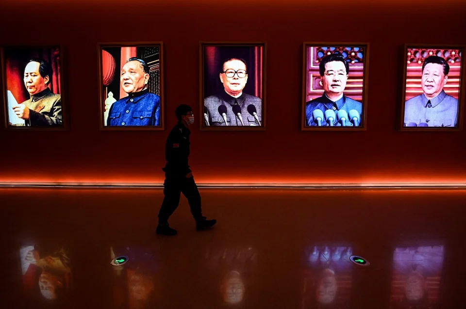 This file photo taken on 15 October 2022 shows a man walking past portraits of (left to right) late Chinese chairman Mao Zedong and former Chinese leaders Deng Xiaoping, Jiang Zemin, Hu Jintao and current president Xi Jinping at Yan'an Revolutionary Memorial Hall in Yan'an city, Shaanxi province, China. (Jade Gao/AFP)
