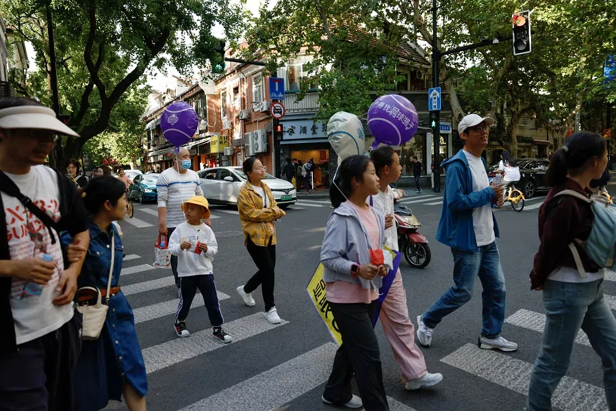 People walk on a street in Shanghai, China, on 4 October 2024. (Tingshu Wang/Reuters)