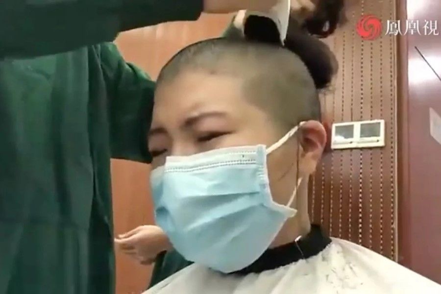 A nurse getting her head shaved in front of the media. (Internet)