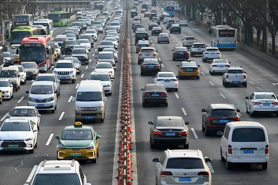Vehicles drive along a street at the central business district in Beijing on 16 January 2024. (Wang Zhao/AFP)
