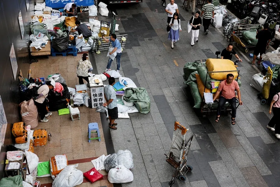 Logistics workers operate along a street in a clothing wholesale district in Guangzhou, Guangdong province, China, 15 April 2026.
