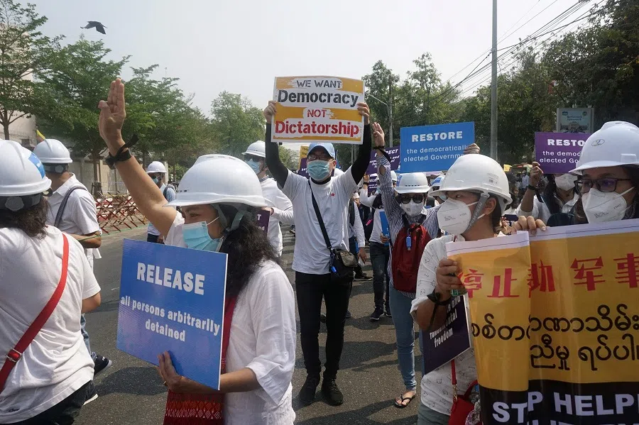 Protesters hold placards as they take part in a march against the military coup, in front of Chinese embassy in Yangon, Myanmar, on 21 February 2021. (Sai Aung Main/AFP)