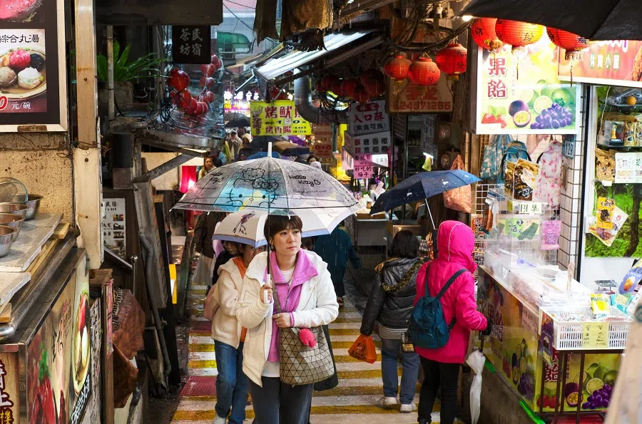 People walk among the old streets in the mountain township of Jiufeng, in New Taipei City, on 16 February 2024. (Sam Yeh/AFP)
