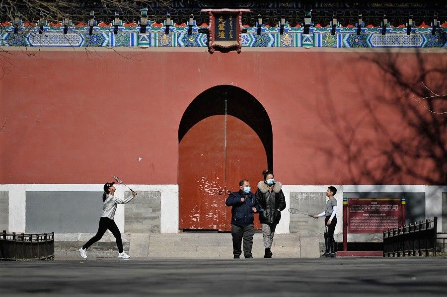 A woman and a child play badminton at a park in Beijing, China on 22 February 2021. (Wang Zhao/AFP)