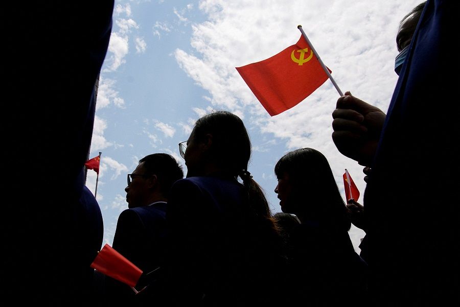 People hold flags of the Communist Party of China as they visit an exhibition at the Memorial of the First National Congress of the Communist Party of China, in Shanghai, China, 22 June 2021. (Aly Song/File Photo/Reuters)