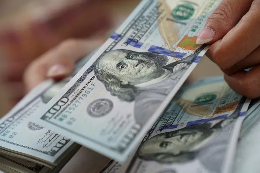 A worker counts US dollar banknotes at a currency exchange office in Jakarta, Indonesia, on 2 March 2022. The dollar is rising against virtually every peer as fallout from the sanctions levied against Russia supercharge demand for the world's reserve currency. (Dimas Ardian/Bloomberg)