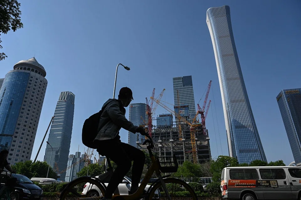 Un uomo va in bicicletta su una strada nel quartiere centrale degli affari di Pechino, Cina, il 17 maggio 2024. (Jade Gao/AFP)