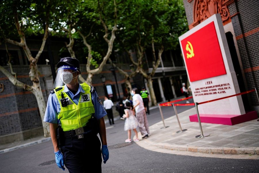 A security guard wearing a face mask following the Covid-19 outbreak keeps watch next to the Chinese Communist Party's emblem at the Memorial of the First National Congress of the Communist Party of China on the 101th founding anniversary of the party in Shanghai, China, 1 July 2022. (Aly Song/Reuters)