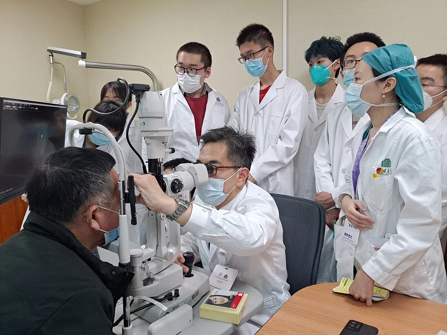 Wong with a patient and students in China.