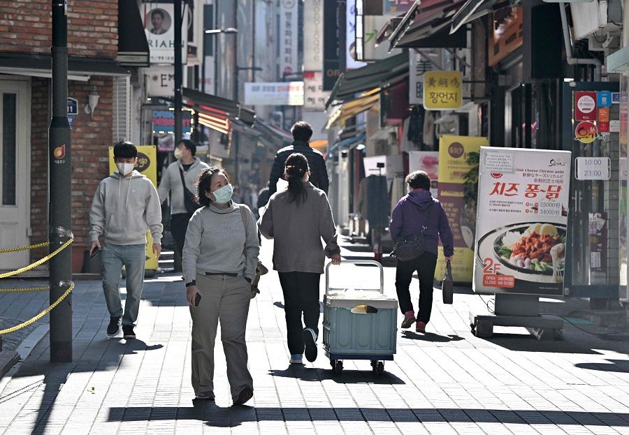 Pedestrians walk through the Myeongdong shopping district in Seoul, South Korea, on 12 October 2022. (Jung Yeon-je/AFP)