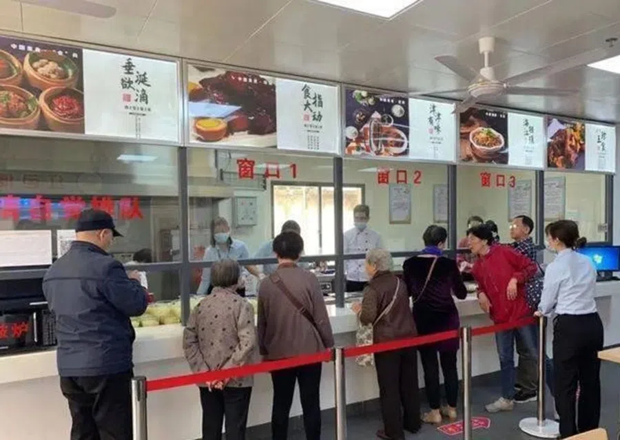 People queue up to buy food at a community canteen in China.