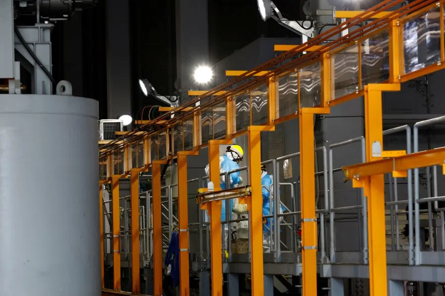 Workers wearing protective gear work at a facility where the water undergoes Advanced Liquid Processing System (ALPS) treatment, at the disabled Fukushima Daiichi nuclear power plant in Okuma town, Fukushima prefecture, Japan, 8 March 2023. (Kim Kyung-Hoon/Reuters)
