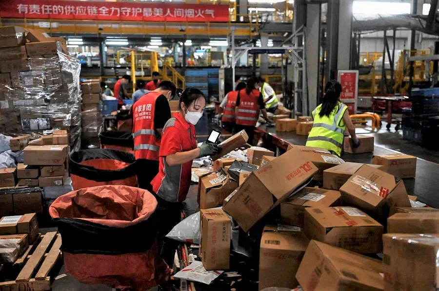 Workers sort packages for delivery at a JD.com warehouse in Beijing, China, on 8 September 2022. (Jade Gao/AFP)