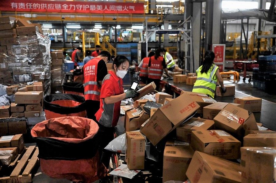 Workers sort packages for delivery at a JD.com warehouse in Beijing, China, on 8 September 2022. (Jade Gao/AFP)