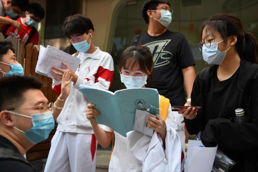 Students get in some last minute study outside a school before entering to sit the gaokao, 7 July 2020. (Greg Baker/AFP)