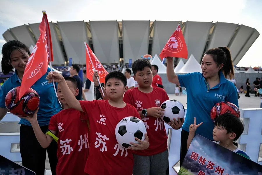 Fans pose for pictures while arriving to watch the amateur league football match between Suzhou and Yangzhou at the Kunshan Olympic Sport Center in Kunshan, in eastern China’s Jiangsu province on 29 June 2025.