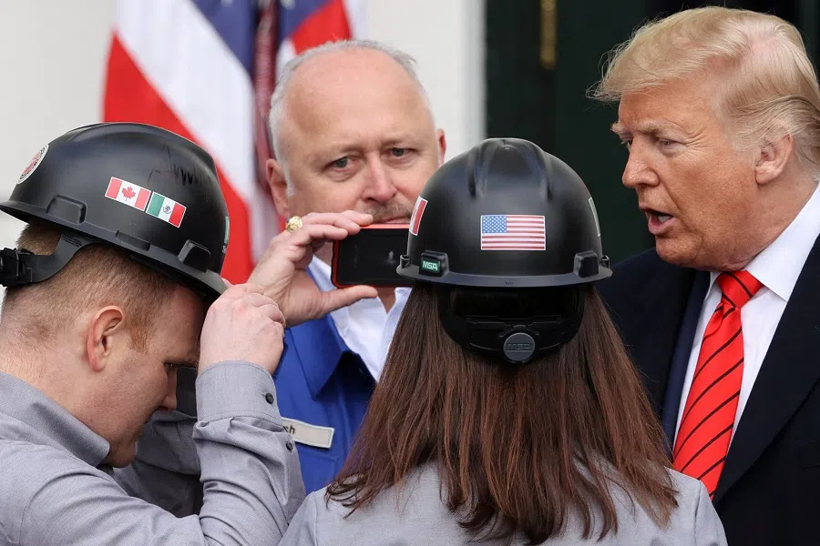 Attendees wearing hard hats with US, Mexican and Canadian flags greet US President Donald Trump after he signed the United States-Mexico-Canada Agreement (USMCA) trade deal at the White House in Washington, US, on 29 January 2020. (Jonathan Ernst/Reuters)