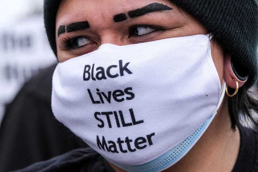 A woman wearing a face mask with the message “Black Lives STILL Matter” takes part in a Black Lives Matter protest in Huntington Beach, California, US, on 11 April 2021. (Ringo Chiu/Reuters)