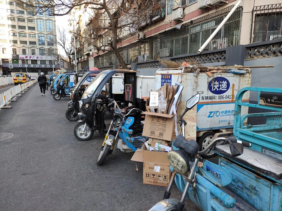 Delivery motorcycles parked by a road.