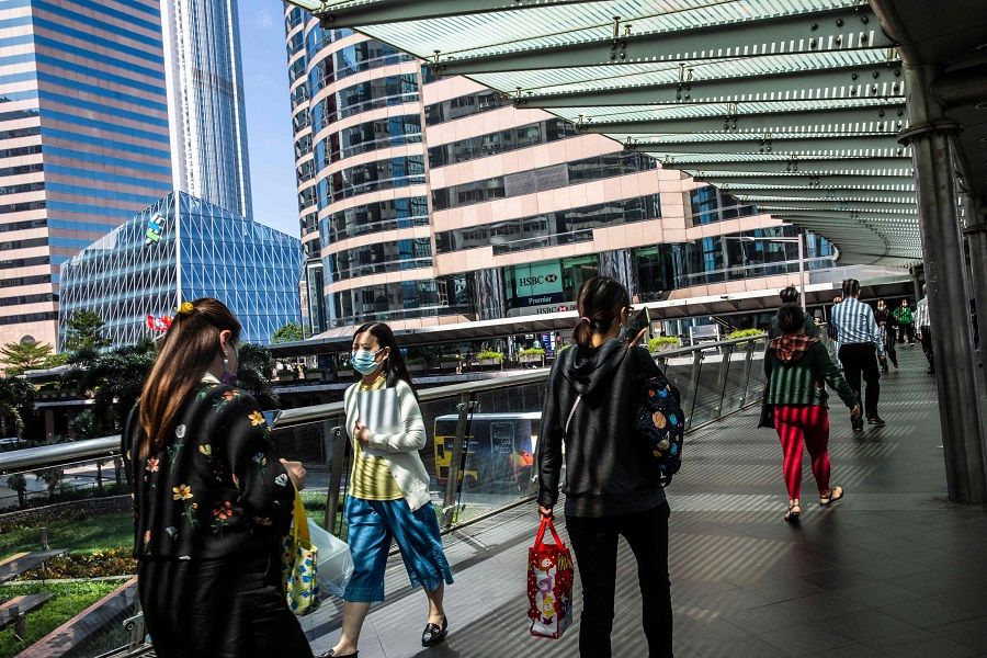 People walk on a foot bridge in the Central district of Hong Kong on 25 October 2021. (Isaac Lawrence/AFP)