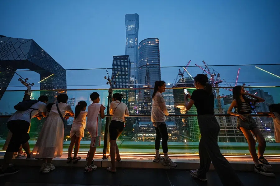 People look at buildings on the skyline from a viewing platform in a mall in Beijing’s central business district on 11 July 2024. (Greg Baker/AFP)