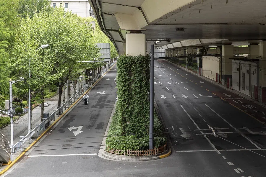 A worker in PPE travels along a near-empty road during a lockdown due to Covid-19 in Shanghai, China, on 25 April 2022. (Bloomberg)