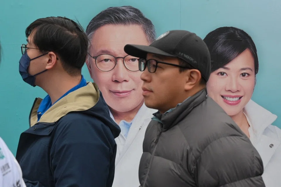 People listen to Ko Wen-je, Taiwan presidential candidate from the opposition Taiwan People's Party (TPP), in front of Ko and his running mate Cynthia Wu's advertisement at the Jhong Yi Taoist temple in New Taipei City on 10 January 2024. (Sam Yeh/AFP)