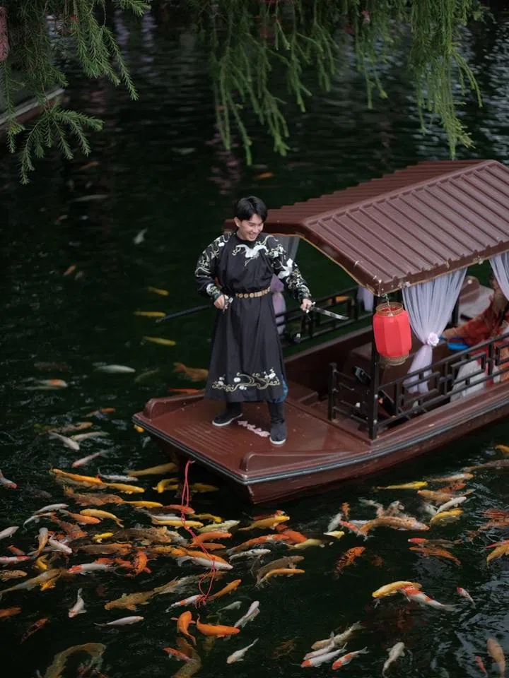 Chen Yan in period costume, feeding fish from a boat at a park in Guangzhou. (Photo provided by interviewee)