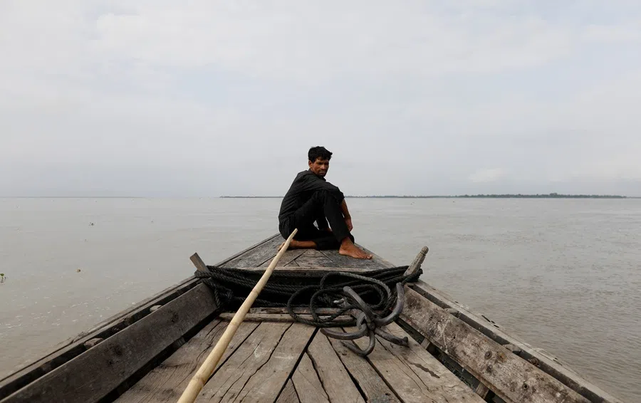 A man sits in a boat on the waters of the Brahmaputra river near the international border between India and Bangladesh in Dhubri district, in the northeastern state of Assam, India, on 4 August 2018. (Adnan Abidi/Reuters)