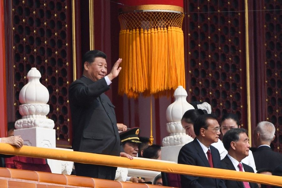 This file photo taken on 1 October 2019 shows Chinese President Xi Jinping (left) waving during the National Day parade in Tiananmen Square in Beijing to mark the 70th anniversary of the founding of the People's Republic of China. (Greg Baker/AFP)