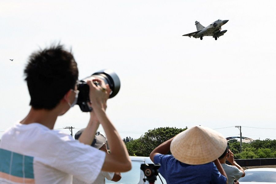People take pictures of a Taiwan Air Force Mirage 2000-5 aircraft landing at Hsinchu Air Base in Hsinchu, Taiwan, 7 August 2022. (Ann Wang/Reuters)
