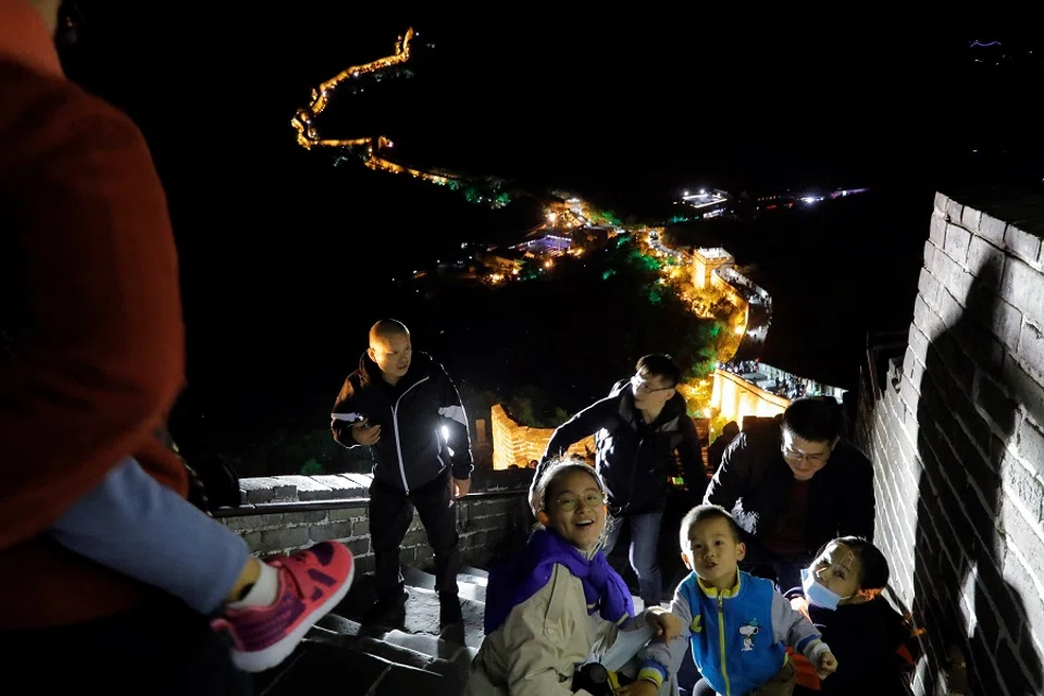 People climb the Great Wall, illuminated to mark the first day of Mid-Autumn Festival and the Chinese National Day, in Beijing, China, 1 October 2020. (Thomas Peter/Reuters)