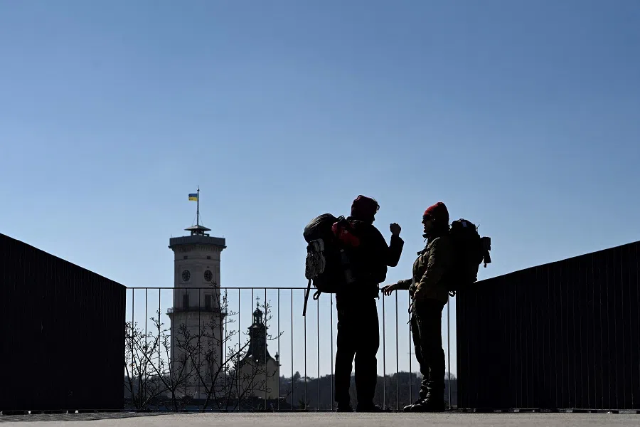 Two men talk as they stand near a balustrades overlooking the western Ukrainian city of Lviv on 19 March 2025, amid the Russian invasion of Ukraine. (Yuriy Dyachyshyn/AFP)